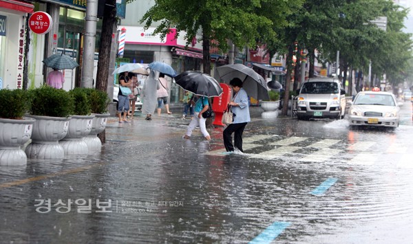 7일 오전 부산에 집중호우가 내리면서 부산 동구 범일동 부산진시장 앞 도로에 물이 고이면서 시민들이 불편을 겪고 있다.     /연합뉴스