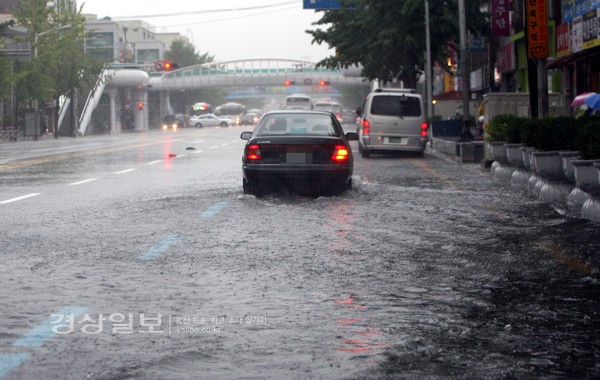 7일 오전 부산에 집중호우가 내리면서 부산 동구 범일동 부산진시장 앞 도로에 물이 고이면서 시민들이 불편을 겪고 있다.     /연합뉴스