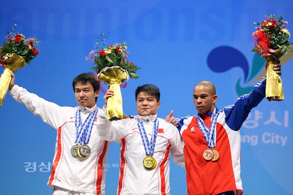 20일 오후 경기도 고양시 킨텍스에서 열린 '2009 세계역도선수권대회'에서 남자부 56kg급 경기에서 1위한 중국의 룽칭치안(가운데), 2위한 중국의 우징뵤우(왼쪽), 쿠바의 세르지오 알바레즈(오른쪽)이 메달을 걸고 함께 기뻐하고 있다.      /연합뉴스