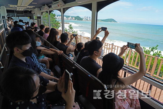 ▲ 해안 방향으로 앉아 바다 풍경을 촬영하는 시민들.